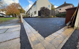 multiple indian sandstone patios leading to double driveway path with sleeper beds and artificial grass in burnley 03