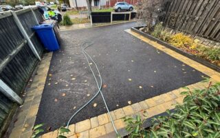 multiple indian sandstone patios leading to double driveway path with sleeper beds and artificial grass in burnley 04
